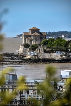 A stunning view of Saint Radegonde Church perched on the rocky coast of Talmont-sur-Gironde, France.