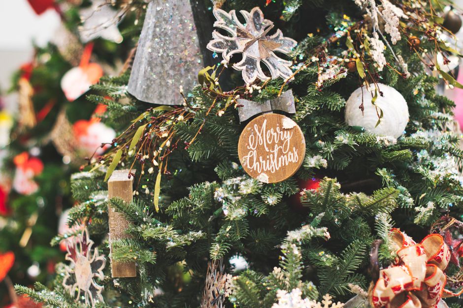 Close-up of a beautifully decorated Christmas tree with festive ornaments and a Merry Christmas sign.