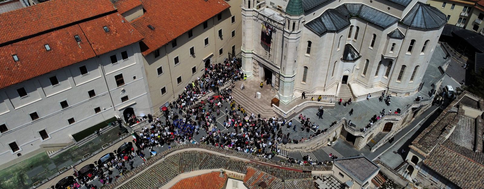 Aerial photograph of the Monastery of Saint Rita in Cascia, Italy, showing crowds gathered in the courtyard.