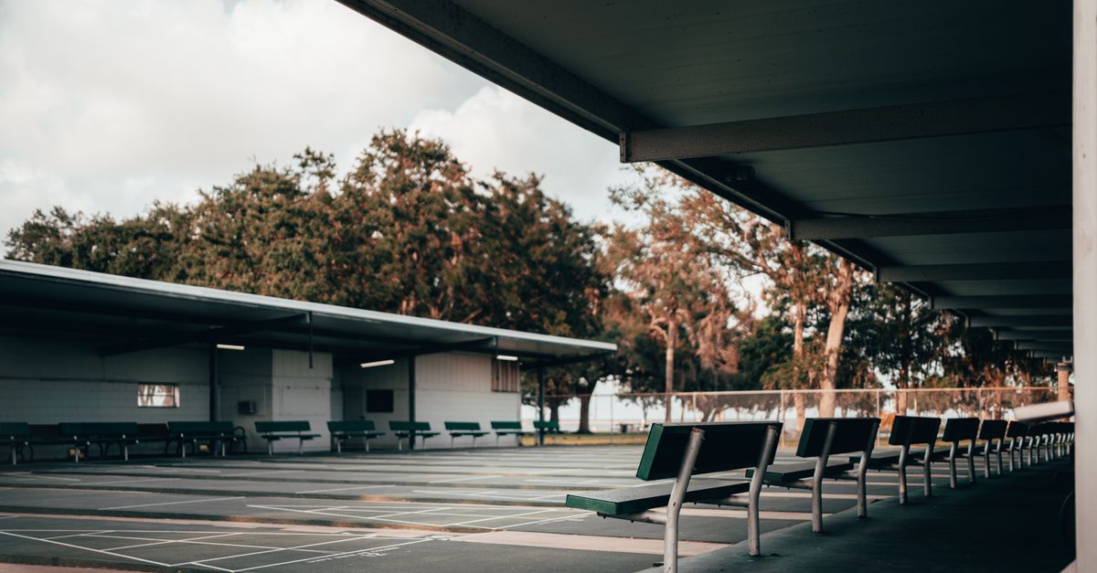 Covered seating area overlooking a recreational facility on a calm day.