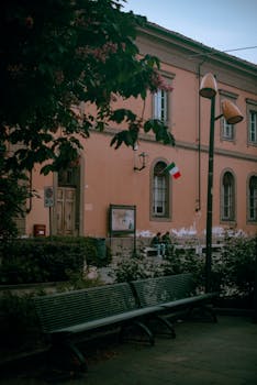 Charming street with Italian flag in Alba, Piedmont. Cultural ambiance with classic architecture.