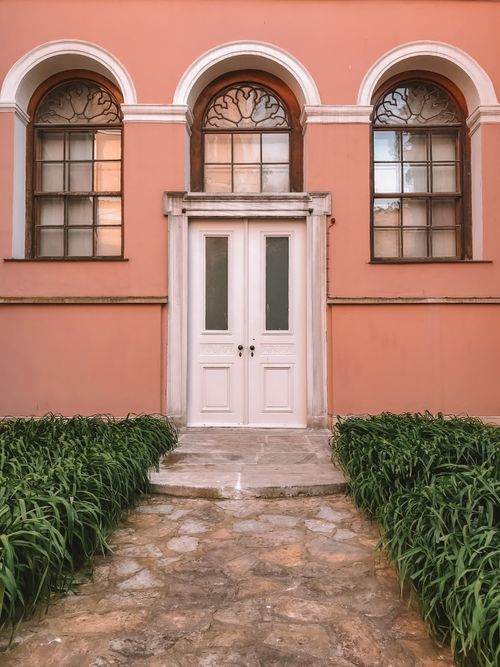 Free Renaissance style building with arched windows and white double doors, featuring a symmetrical facade. Stock Photo