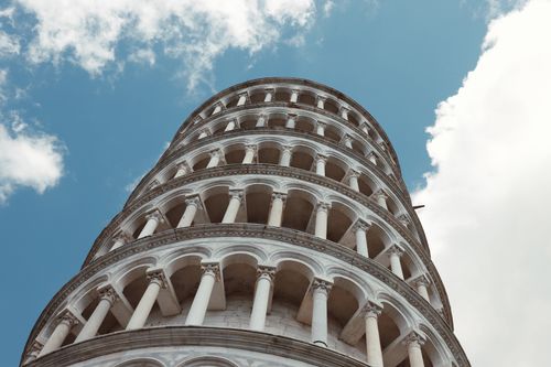Free Close-up of the iconic Leaning Tower of Pisa with beautiful arches and a clear blue sky. Stock Photo