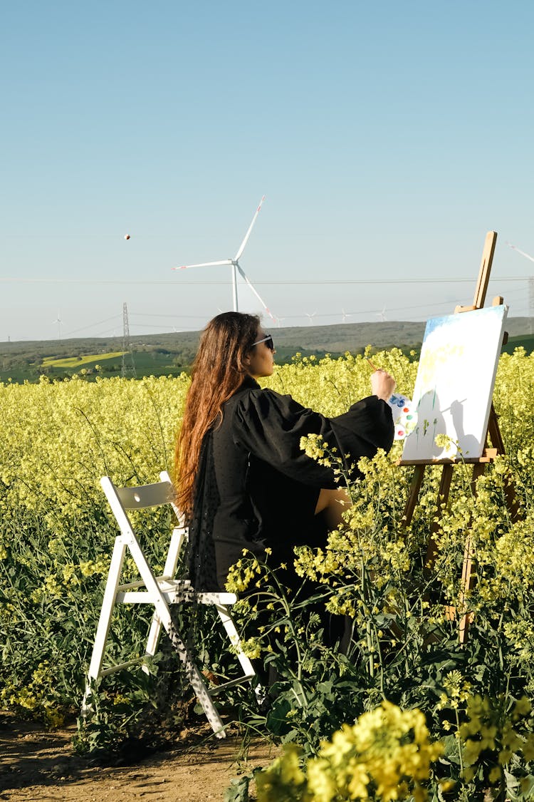 Young Model Painting In A Rapeseed Field