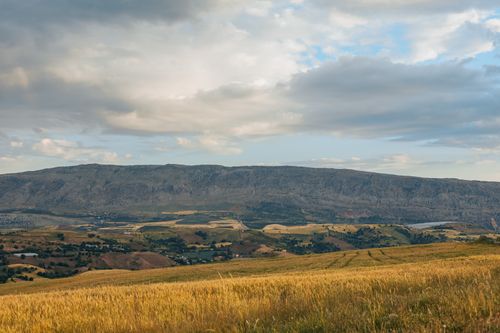 Free Breathtaking view of a mountain range overlooking a lush valley with scattered villages. Stock Photo