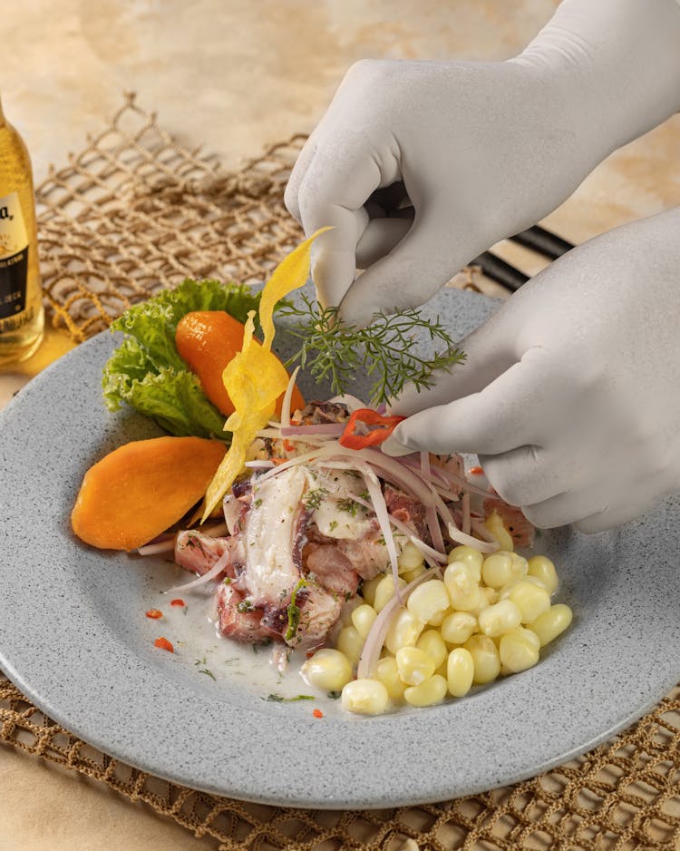 Chef Hands In Gloves Decorating Dish In Plate