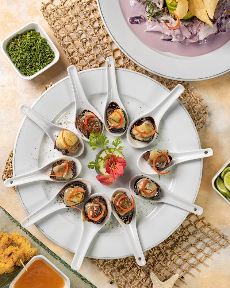 Spoons With Snacks On Plate In Restaurant