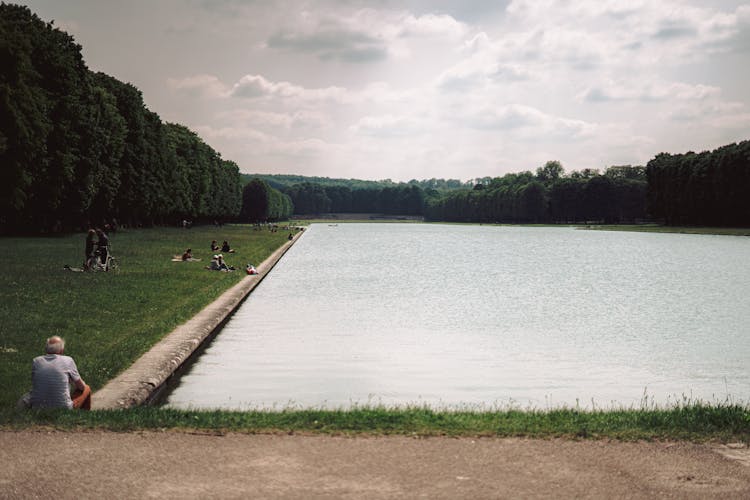 People Relaxing At The Canal In Versailles, France