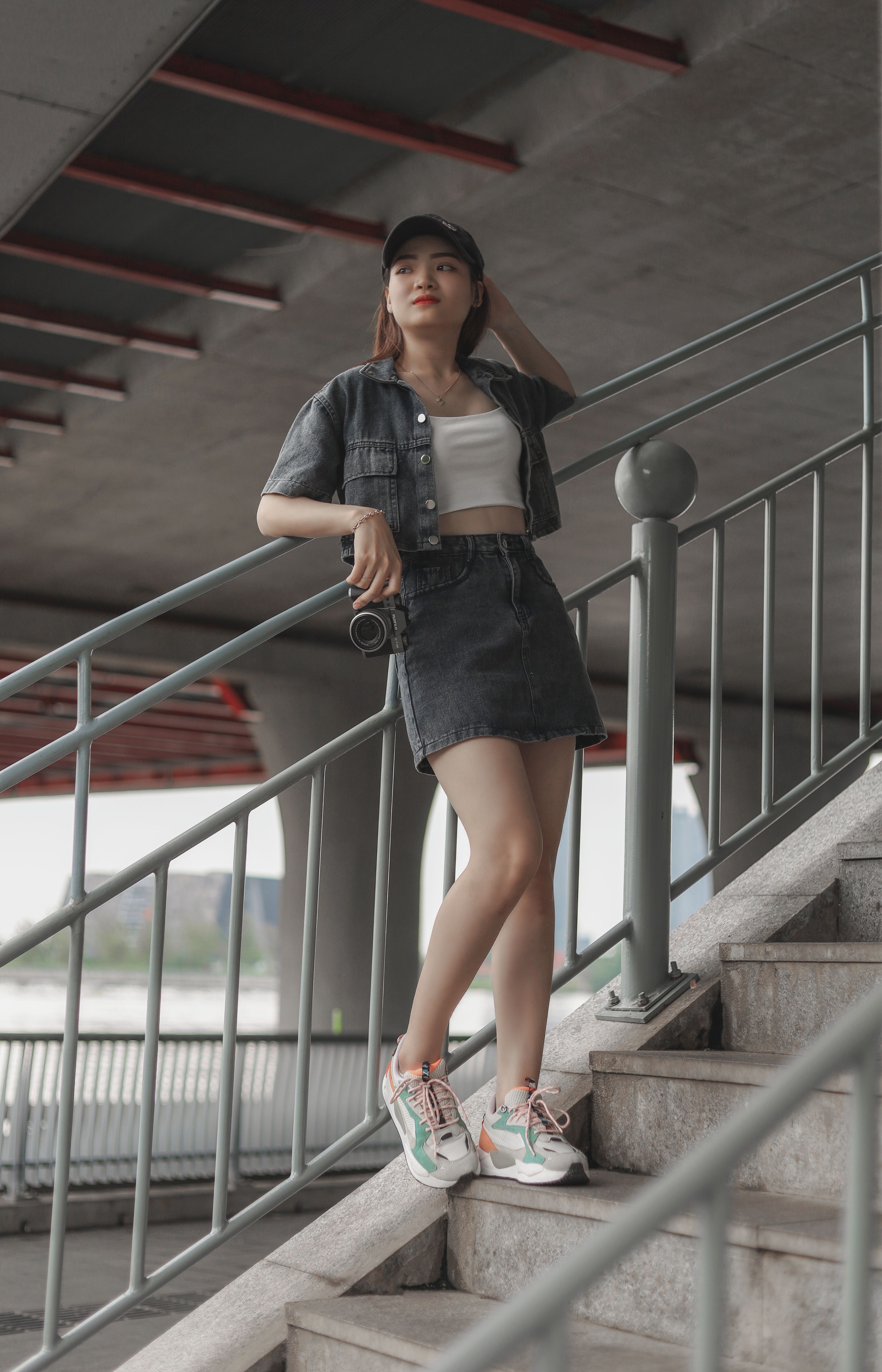 Woman in a baseball cap, jean jacket and denim mini skirt