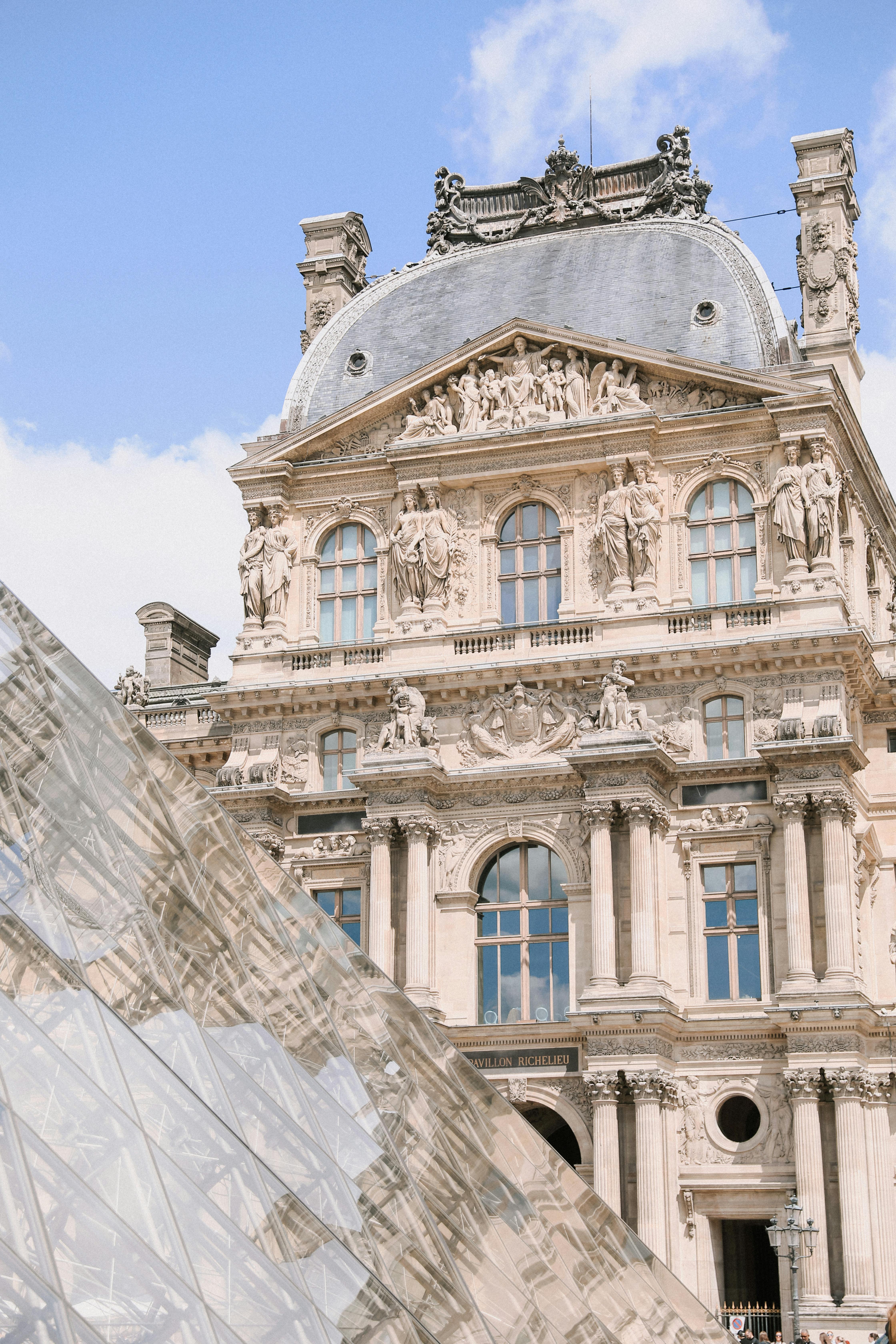 Detailed view of the Louvre Museum's historic architecture and modern pyramid in Paris.