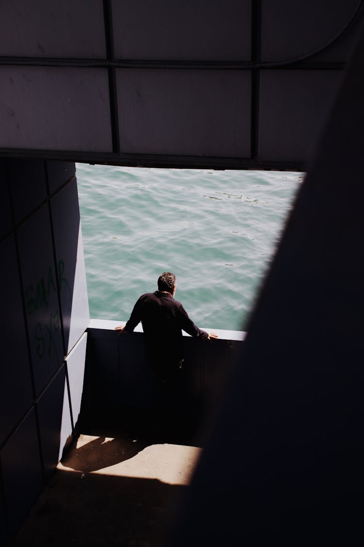 Man Standing By Wall Near Water