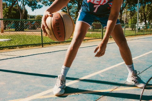 Young Man Playing Basketball Outdoors 