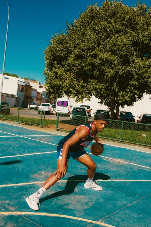 Young Man Playing Basketball Outdoors 