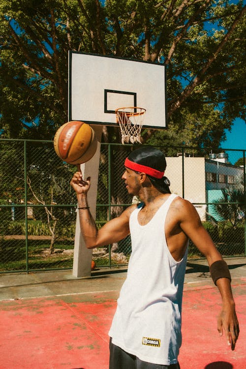 Young Man Spinning a Basketball Ball on the Finger 