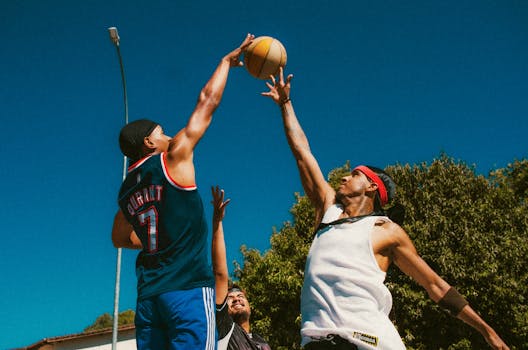 Energetic street basketball game with young men competing intensely outdoors on a sunny day.
