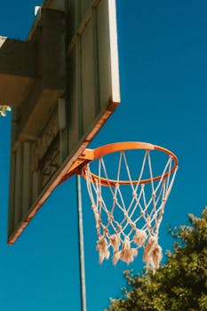 Basketball hoop outdoor under clear blue sky, perfect for sports visuals.