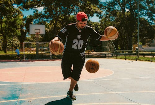 Young Man Playing Basketball Outdoors 