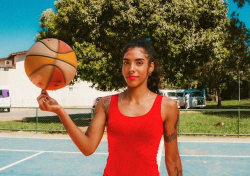 Young Woman Spinning a Basketball Ball on Her Finger