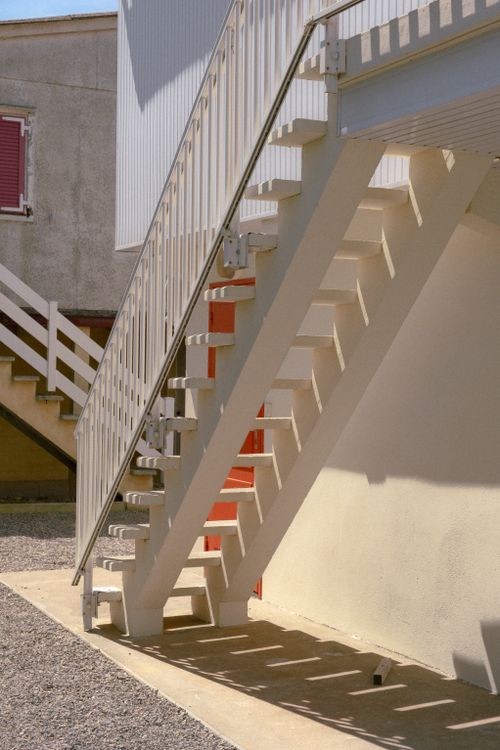 Free Exterior staircase with geometric lines casting shadows on a sunny day. Stock Photo
