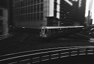 在繁华的城市夜景中，一列火车穿行而过，动态黑白照片定格了这一瞬间