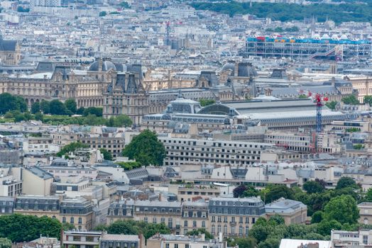Aerial view of Paris showcasing the Louvre Museum and iconic cityscape in a summer setting.
