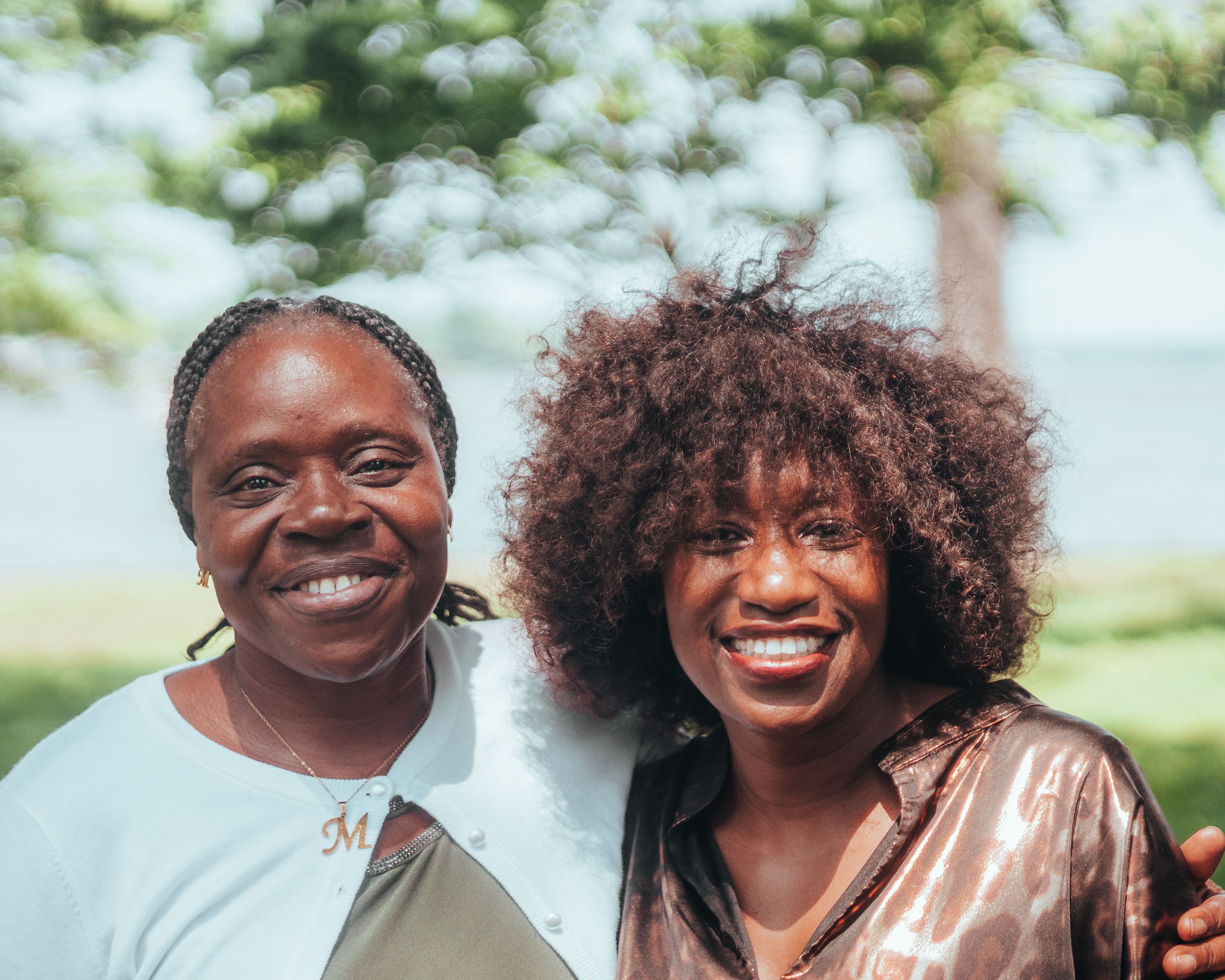 Portrait of Two Women Standing and Embracing in a Park · Free Stock Photo