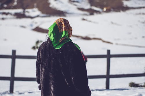 Селективная фокусировка фотографии человека, стоящего на снежном поле