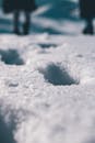 雪地上波光粼粼的脚印特写，捕捉到了寒冷的冬季气氛