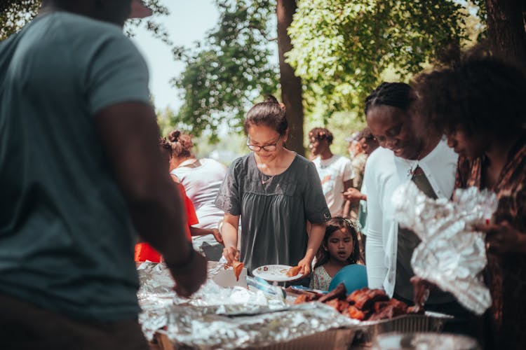 People Taking Food On Plate At Garden Party