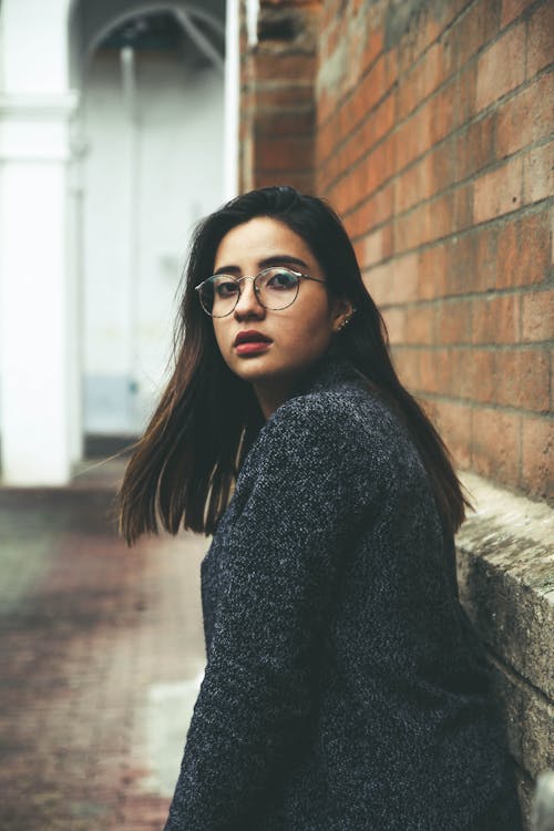 Woman in Eyeglasses Posing by Wall