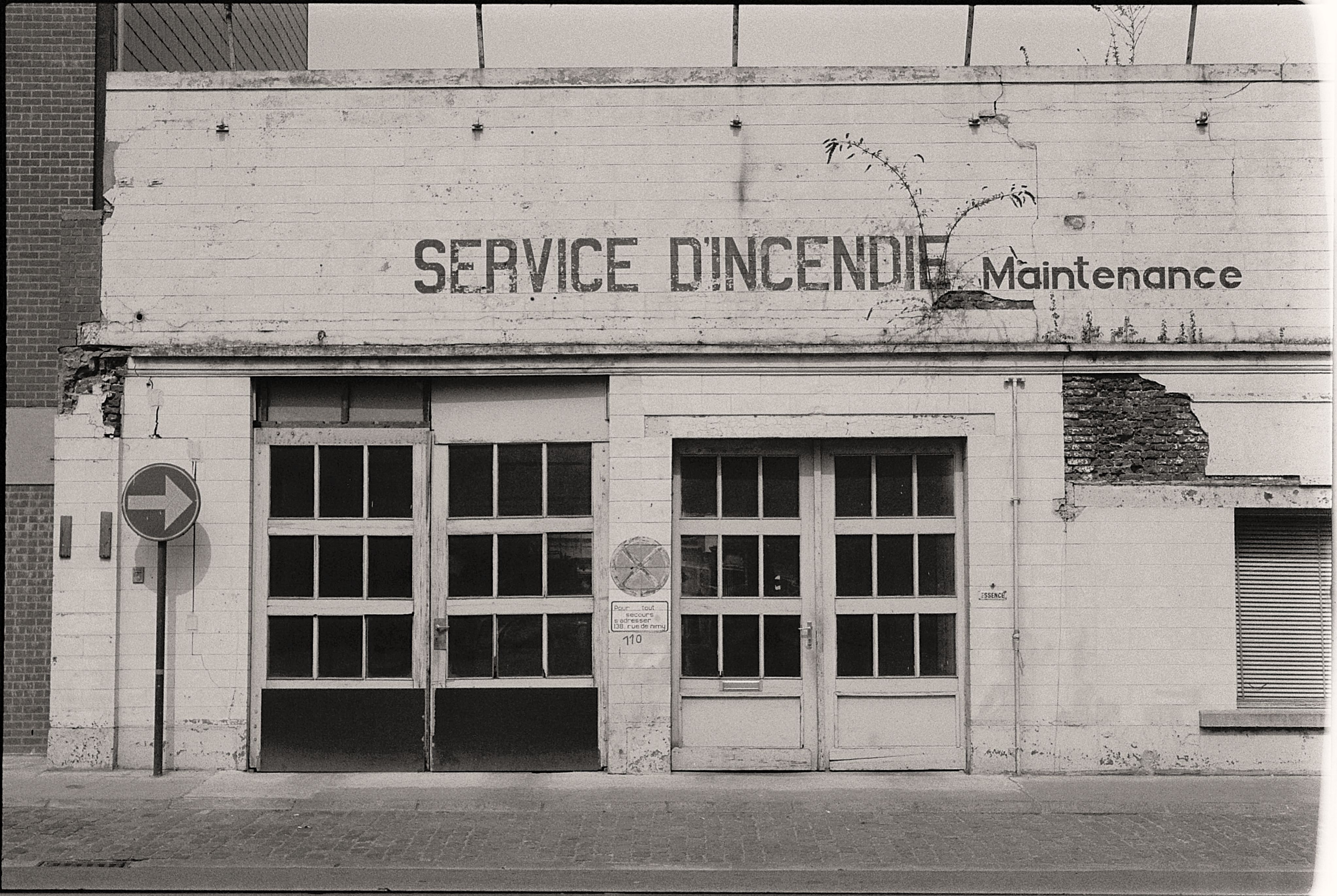 A black and white photo of an old fire service maintenance garage with signage.