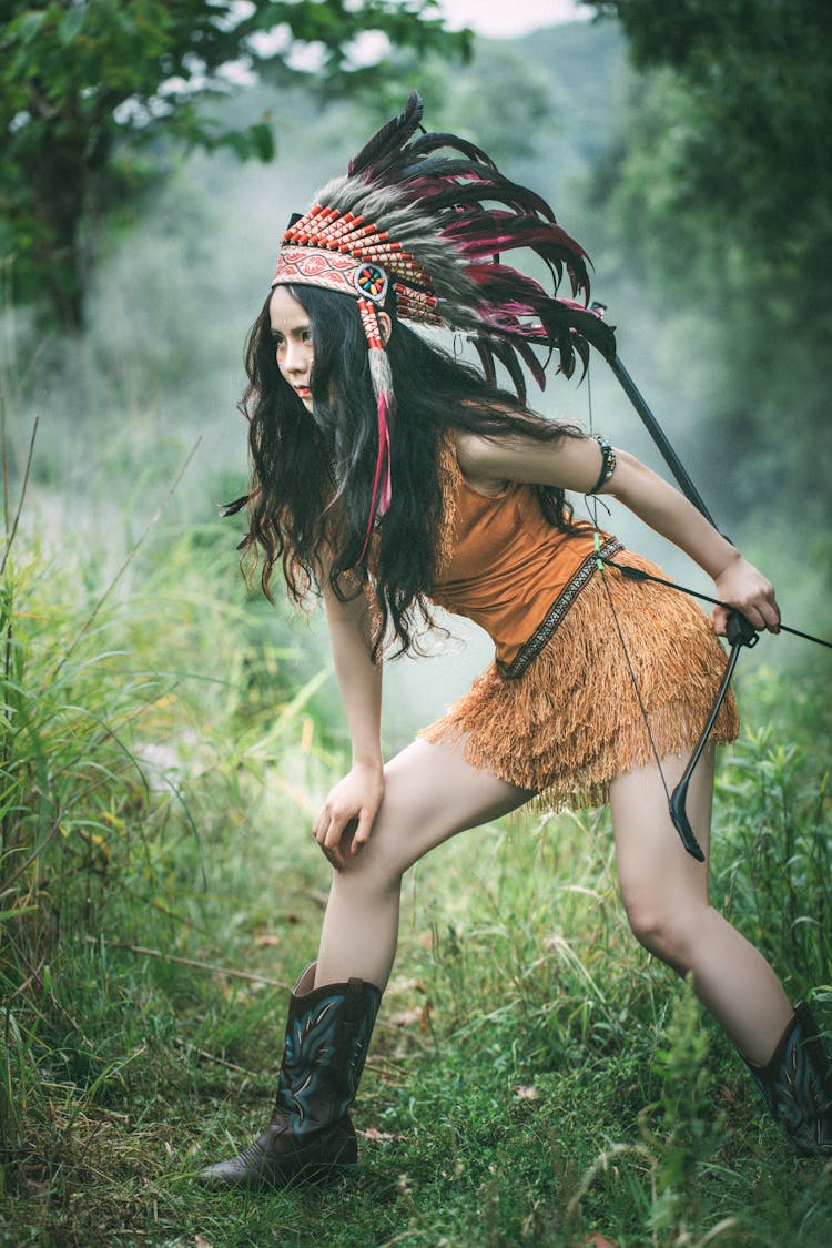 Woman In Native American Clothing With A Bow In Her Hand 