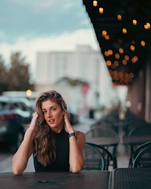 Woman Sitting by Table at Cafe