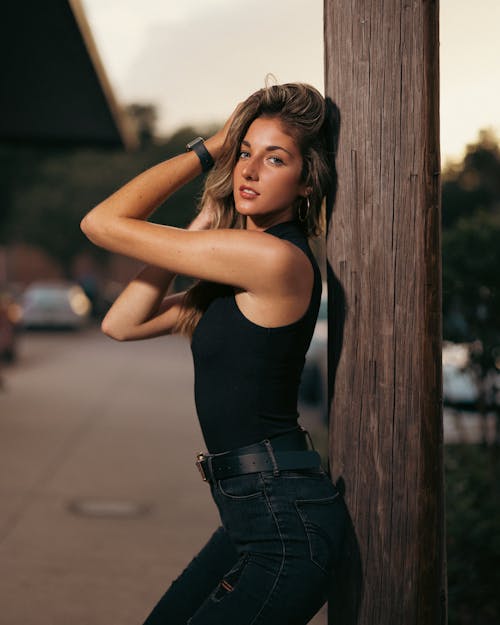 Blonde Woman Standing by Wooden Pole