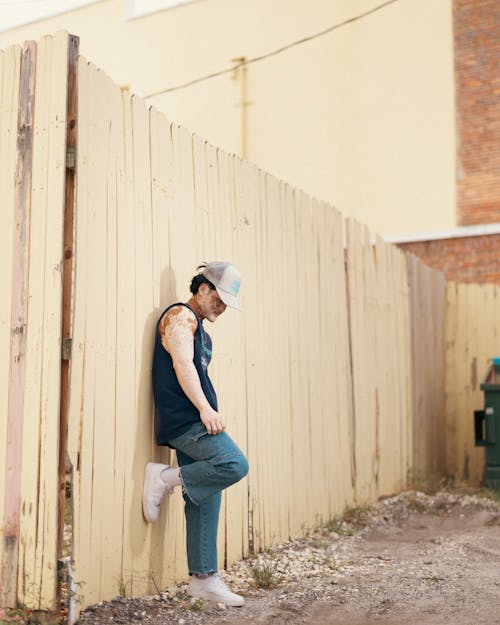 Man Posing in Front of Wooden Fence 