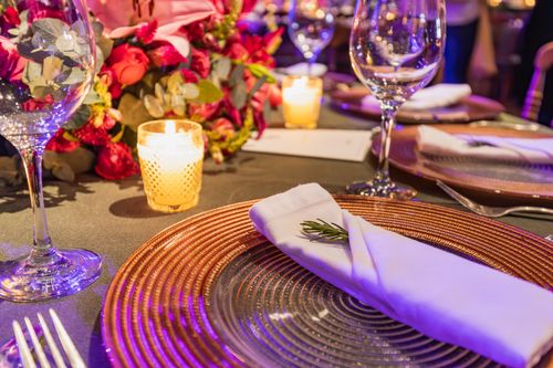 Free Close-up of a chic table setting with flowers, glassware, and candlelight ambiance. Stock Photo