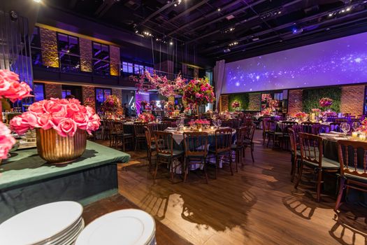 Luxurious indoor dining setup with vibrant floral arrangements and elegant lighting.
