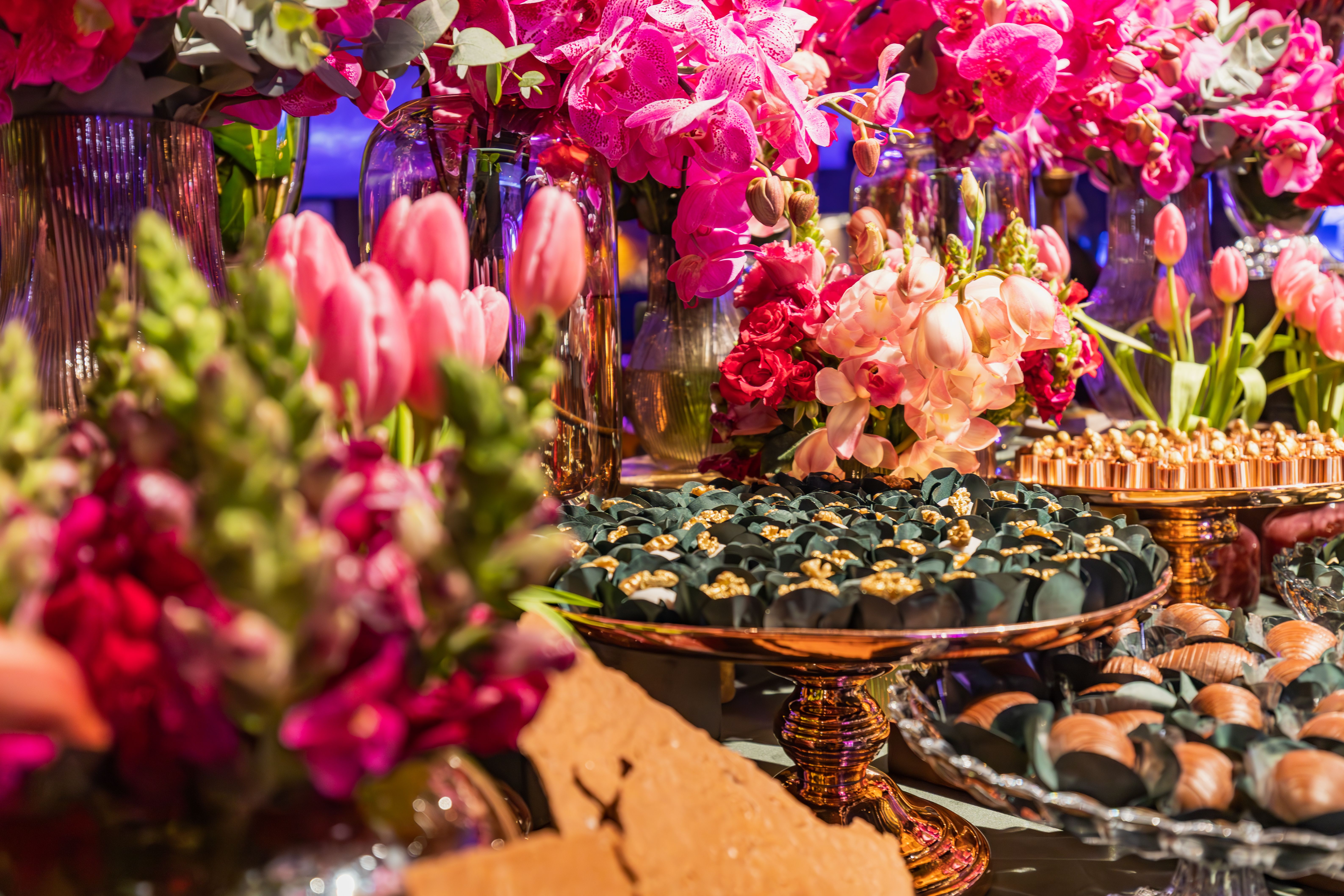 Bright floral arrangement with elegant desserts in a festive setting.