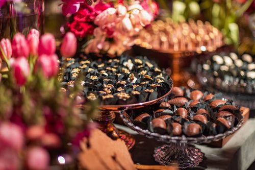Free Close-up shot of assorted chocolates displayed with vibrant tulips, creating a luxurious setting. Stock Photo