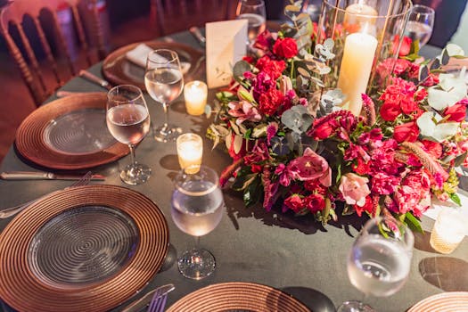 Luxurious table setting with elegant floral centerpiece and candles at a celebration.