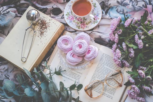 Free Floral Ceramic Cup and Saucer Above Open Book Stock Photo