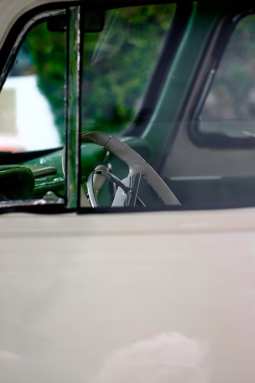 Close up of Vintage Car Window and Steering Wheel behind