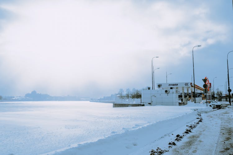 Frozen River And Snow Near Oil Station