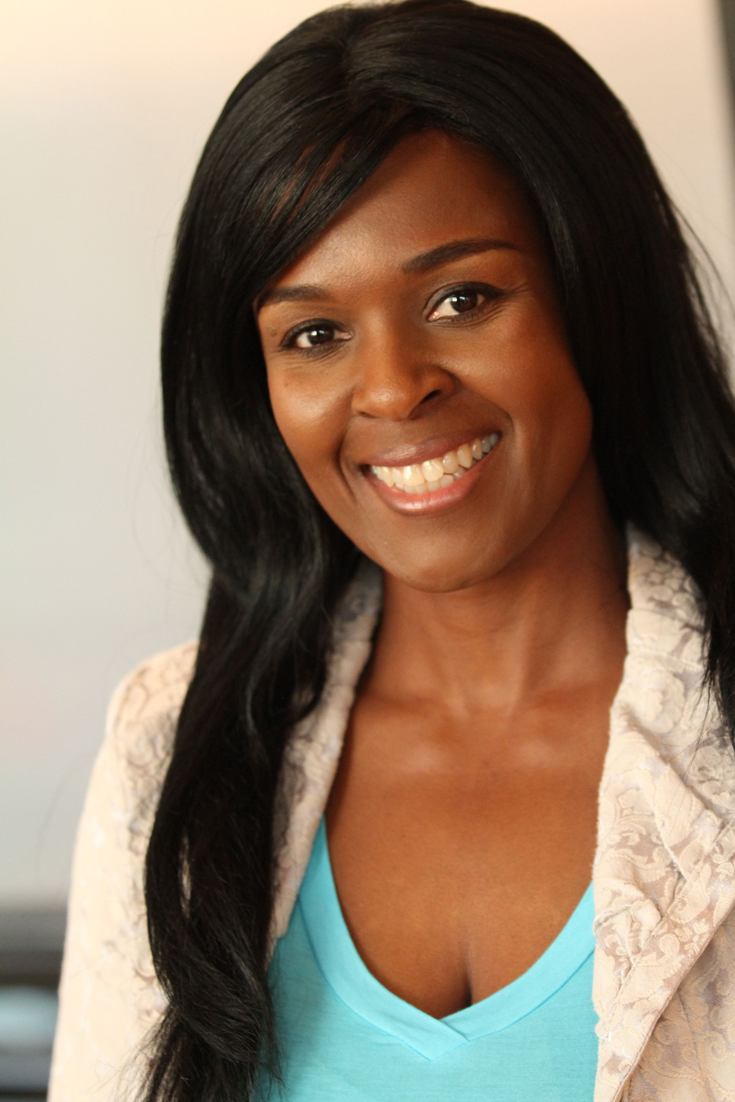 Portrait of a smiling woman with long black hair and blue top.