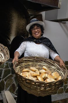 Smiling woman in Junín, Perú, holding a basket of fresh bread, showcasing traditional baking.
