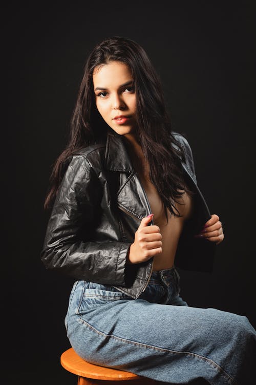 Woman Sitting and Posing in Leather Jacket
