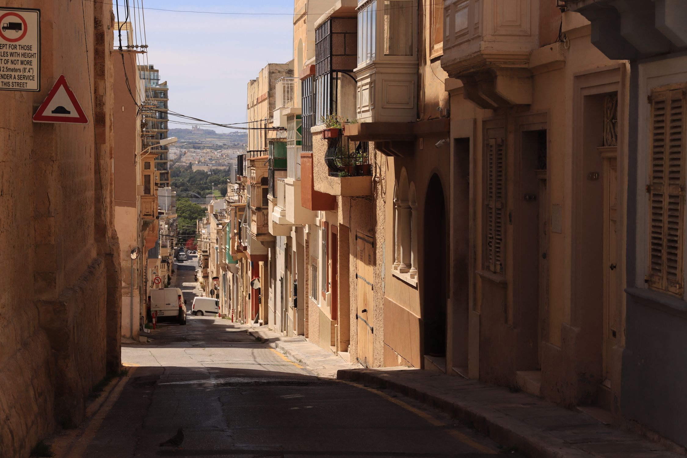 Explore a picturesque narrow street in Valletta, Malta, showcasing historic architecture and urban charm.