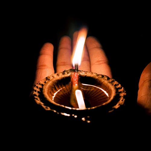 Fotos de stock gratuitas de capturando el brillo, decoración diya, diya en mano