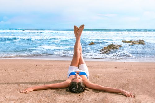 Free Woman enjoys a sunny day lying on the sandy beach, soaking in the sea breeze in Tacna, Peru. Stock Photo