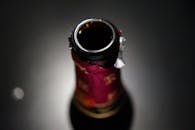 一张聚焦特写的图像，展示了一个打开的酒瓶，背景黑暗而模糊